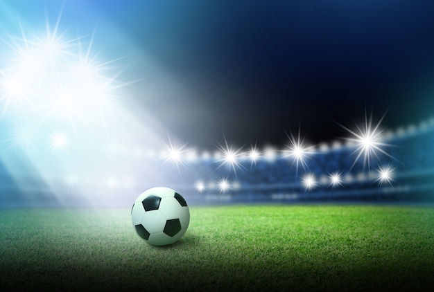 Футбольный мяч на зеленой траве на стадионе с подсветкой
