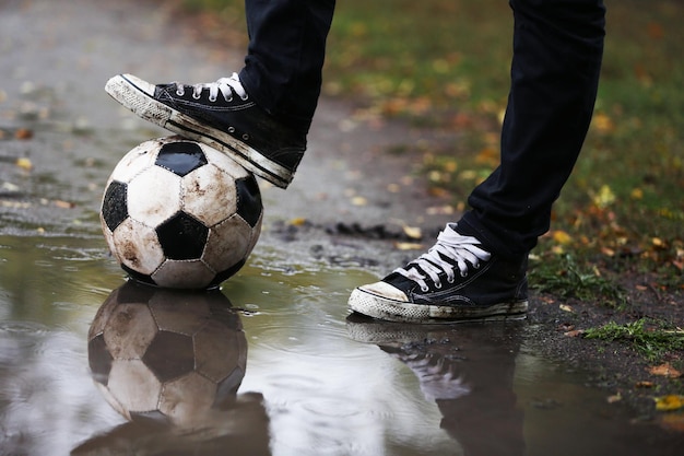 雨の日の屋外で地面にサッカー ボール