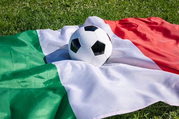 Foto pallone da calcio sulla superficie della bandiera italiana sulla partita di apertura del campionato europeo di erba verde di