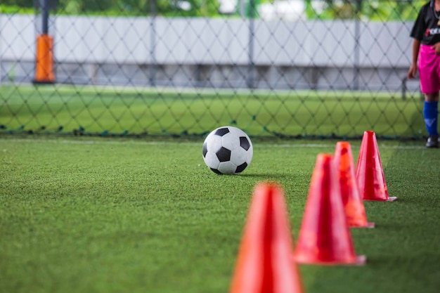 Soccer ball tactics cone on grass field with for training\
background training children in soccer