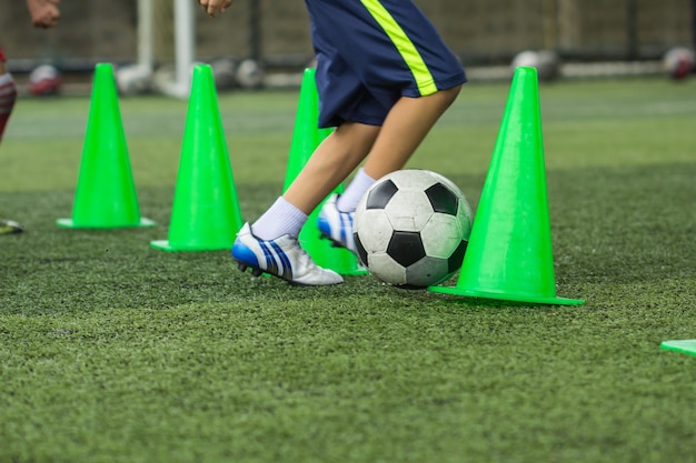 Soccer ball tactics on grass field with cone for training thailand in  background Training children in Soccer academy