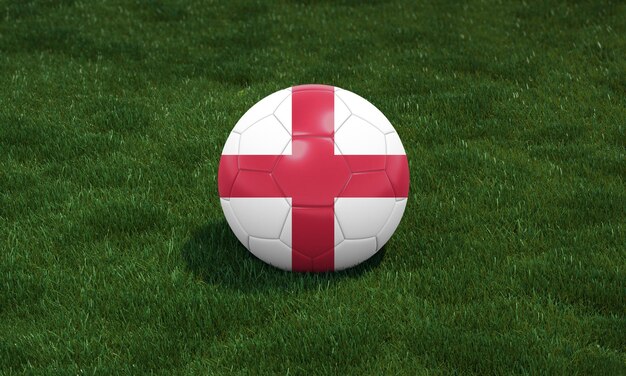 Soccer ball with England flag colors at a stadium on green grasses background