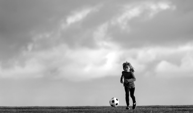 サッカーの子供はサッカーボールのバナーコピースペースbを蹴るゴールの子供を撃つサッカーの小さな男の子を再生します