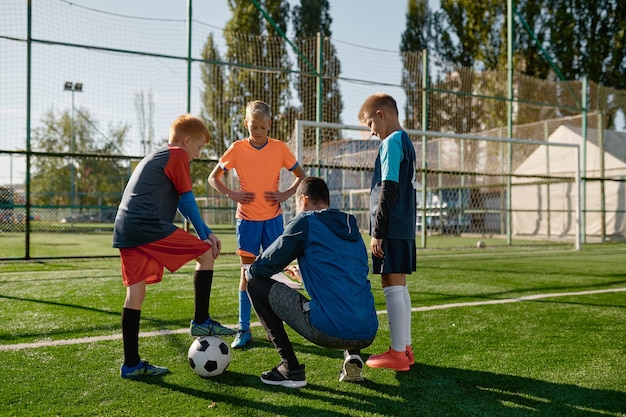 Foto l'allenatore di calcio rivede le strategie con i giovani calciatori