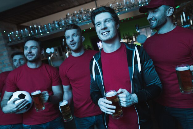 Soccer fans celebrating and drinking beer.