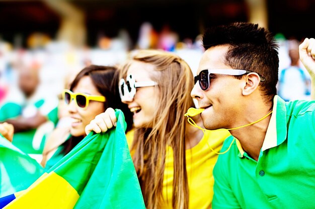 サッカーの試合でブラジルの旗を掲げるサッカーファン