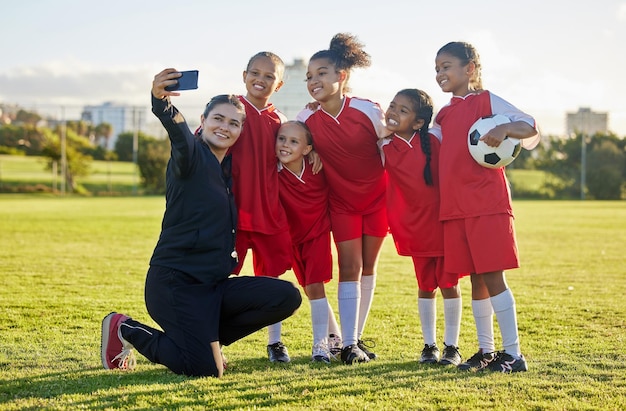 Photo soccer field girl team and coach selfie for social media after training competition and game together outdoors happy children smile teacher and students community football academy taking photos