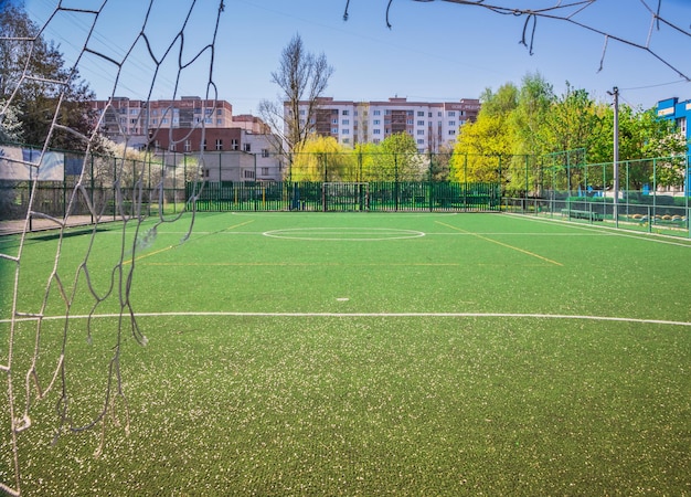 Photo soccer field with artificial green grass near the school amateur football field sunny summer day