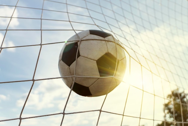 Soccer field with a ball in goal against cloudy sky and the bright sun the concept of success and victory Summer game of European football