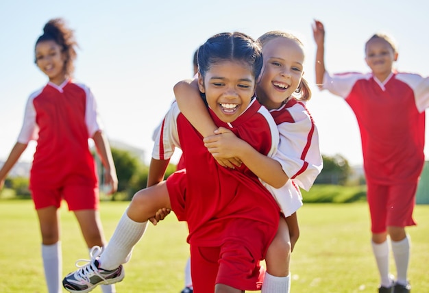 Soccer girl celebration and field with happy piggyback team building support and solidarity for winning game Female kids sports diversity and celebrate with friends teamwork and goal in football