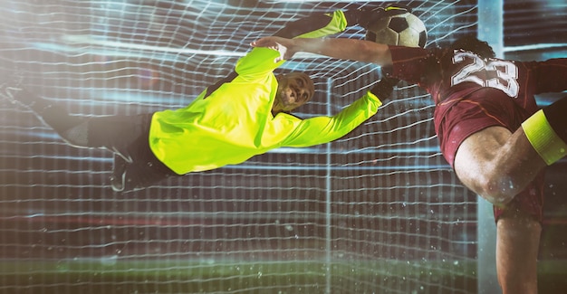 Photo soccer goalkeeper in fluorescent uniform makes a save on a close head shot of the attacker