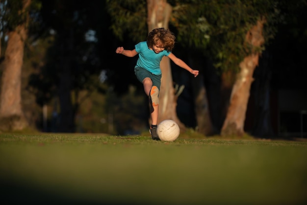 Футбол дети ребенок мальчик играть в футбол на открытом воздухе молодой мальчик с футбольным мячом делает удар футбол футбол pl ...