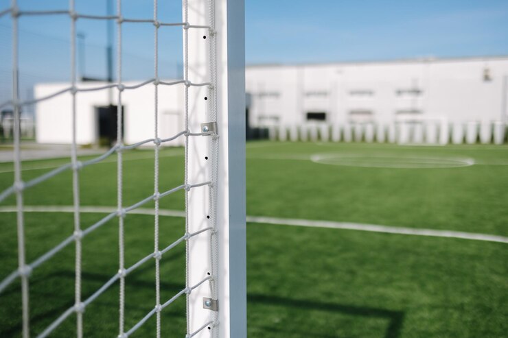 ぼやけたフィールド ピッチ サッカーの試合でゴールの後ろからサッカー ネット背景ビュー