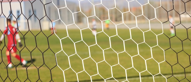 Photo soccer nets and football game in arena blurred players background