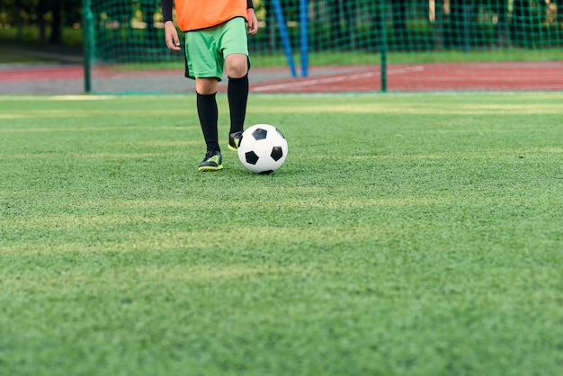 Soccer player kicking ball on field