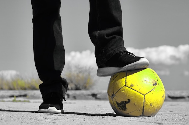 Photo a soccer player pressing his foot on the ball.