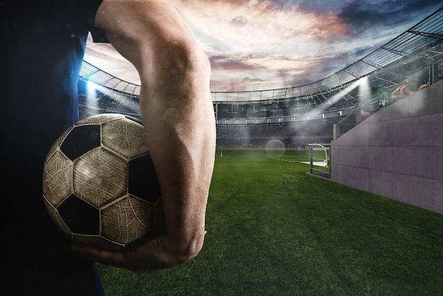 Soccer player ready to play with ball in his hand at the entrance of the football field