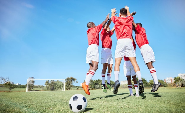 トレーニングや練習中に芝生のピッチやフィールドでジャンプするチームとのサッカー スポーツとモチベーション トレーニング中に一緒に祝うアスリート グループとのフィットネス フットボールとエクササイズ