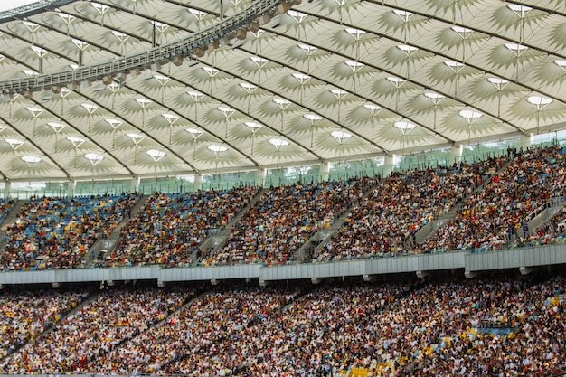 サッカー スタジアムの内部ビュー サッカー場が空に立っているファンの群衆が空を背景に屋根を立っています