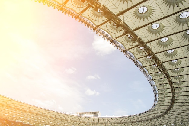 Soccer stadium inside view football field empty stands a crowd of fans a roof against the sky