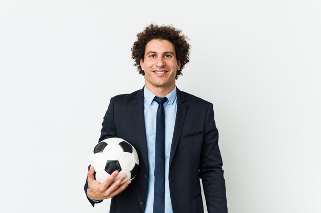 Soccer trainer holding a ball happy, smiling and cheerful.