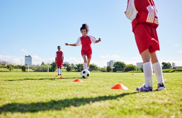 Тренировка по футболу или бег, и женская команда вместе играет с мячом на поле для тренировок Фитнес-футбол и трава со спортивными детьми, играющими на поле для соревнований или упражнений