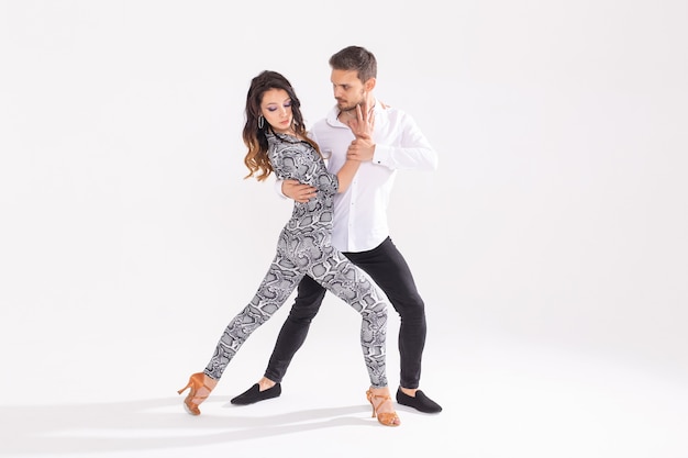 Sociaal dansconcept - Actieve gelukkige volwassenen die bachata of salsa samen dansen over witte achtergrond met exemplaarruimte