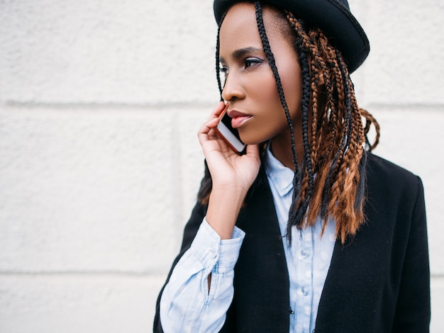 社会的コミュニケーション。ファッション黒人少女の肖像画。自由空間と白い背景の上のアフリカ系アメリカ人の女性。現代の若者、美しさの概念