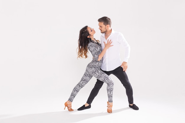 Social dance concept - Active happy adults dancing bachata or salsa together over white background with copy space