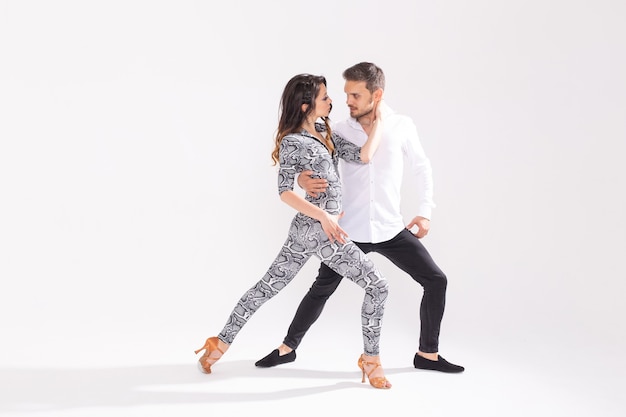 Social dance, kizomba, tango, salsa, people concept - beautiful couple dancing bachata on white background with copy space