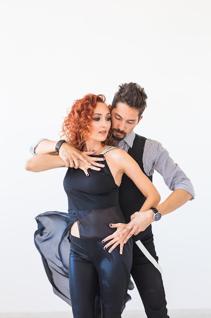 Social dance, salsa, zouk, tango, kizomba concept - beautiful couple dancing bachata on white