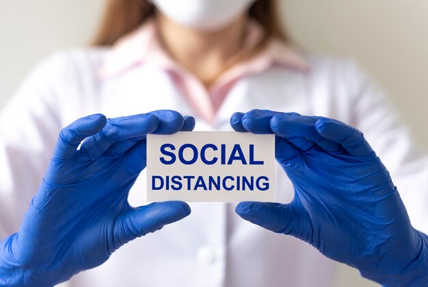 social distancing text on a paper in doctor hands