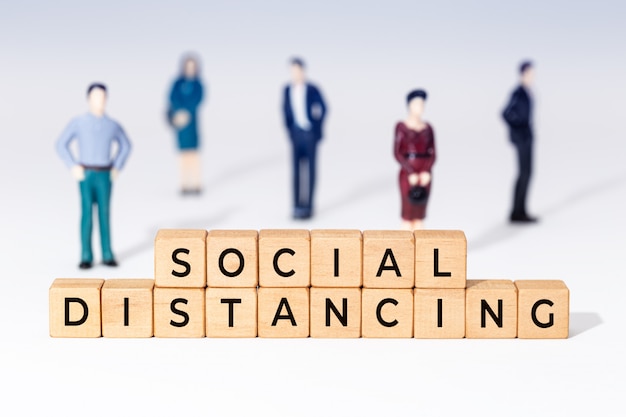 Social distancing in wooden blocks and little figurines