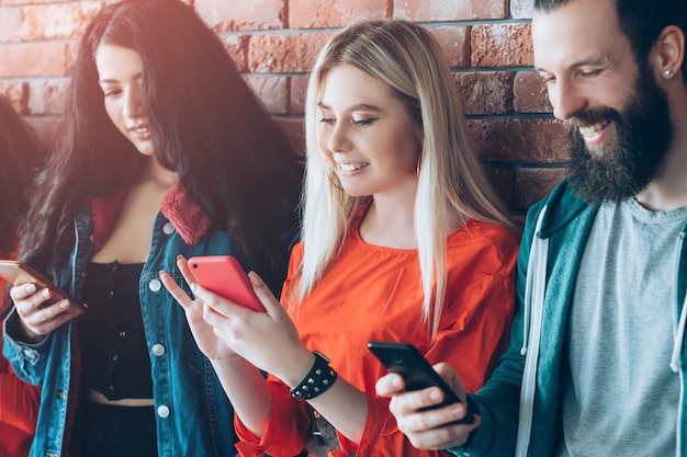 Foto dipendenza dai social. fila le persone con gli smartphone. stile di vita dei millennials. tempo libero tecnologico.