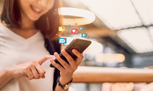 Social media and digital online , smiling Asian woman using smartphone and show technology icon.