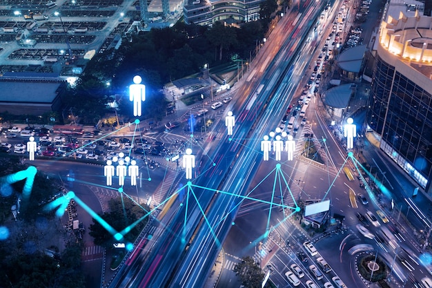 Social media icons hologram on top view of road busy urban\
traffic highway at night junction network of transportation\
infrastructure the concept of networking and success double\
exposure