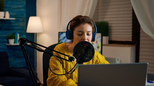 Social media influencer openende laptop begint nieuwe podcast op te nemen vanuit thuisstudio. On-air online productie internetuitzending show host streaming live inhoud, opnemen van digitale video vlog