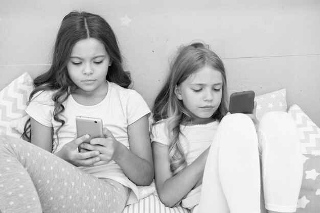 Social problem morning vibes chatting before sleep best friends sisters use phone in bed sweet dreams pajama party in bedroom childhood with new technology internet surfing kids are blogging