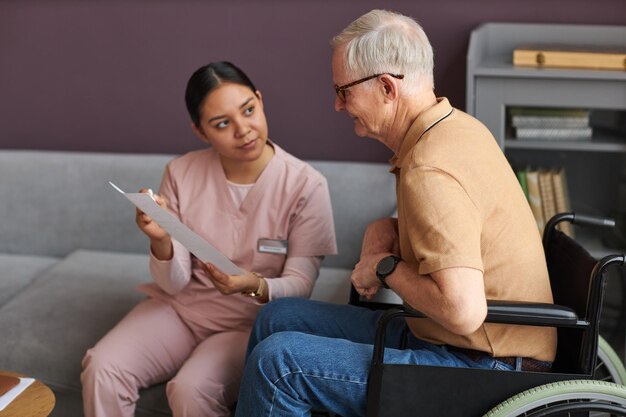 Social worker examining bills with senior man