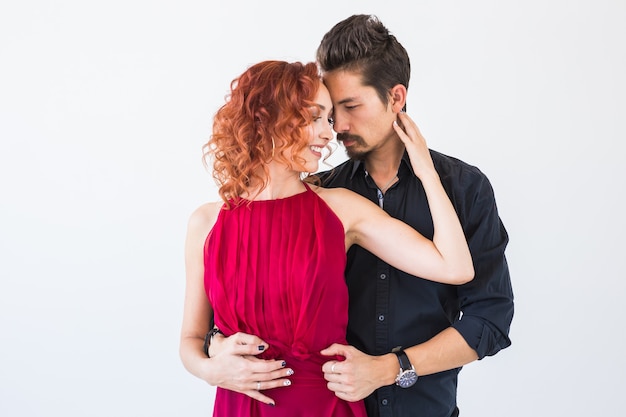 Sociale dans, bachata, kizomba, salsa, tangoconcept - sluit omhoog portret van vrouwenman gekleed in mooie outfits over witte muur.