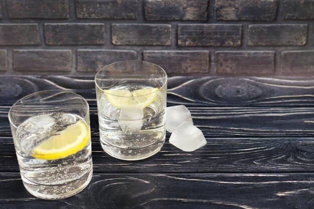 Газированная вода в стеклянных стаканах с лимоном и льдом