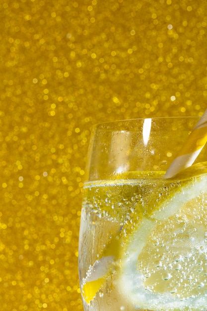 Soda with lemon on golden background