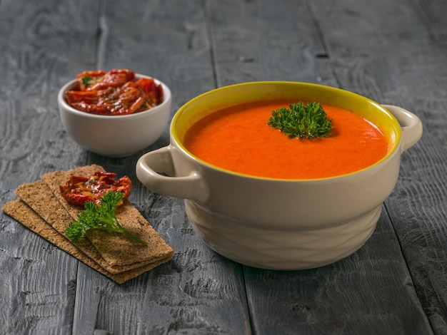 Soep fijngestampte groenten en gedroogde tomaten met brood toast op een houten tafel