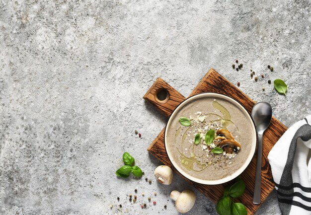 Soeppuree met champignons en parmezaan op een betonnen keukentafel