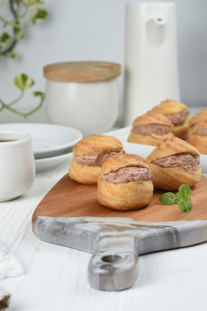 soezendeeg of slagroomsoesjes gevuld met chocolade vla witte achtergrond