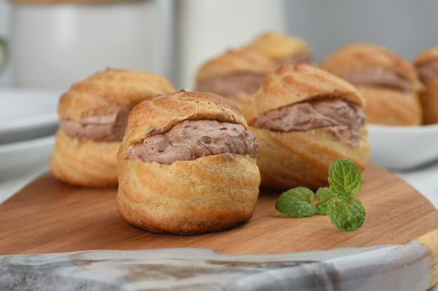 soezendeeg of slagroomsoesjes gevuld met chocolade vla witte achtergrond