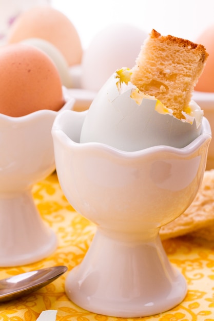 Яйцо всмятку в яичной чашке и подается с гренками.