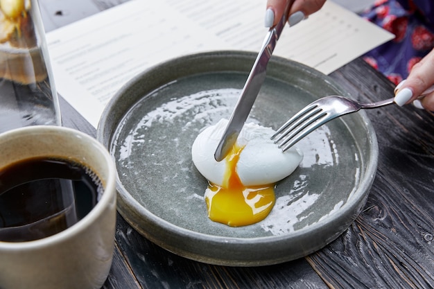 Яйцо всмятку режется ножом, а желток льется на серую тарелку