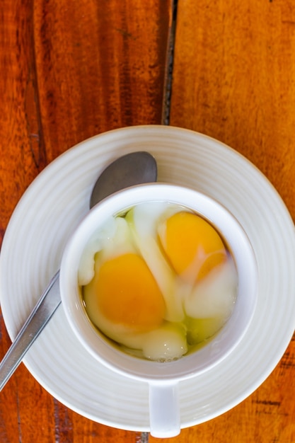 Soft boiled egg in white cup with spoon morning food