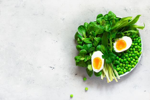 Soft-boiled eggs with herbs and green peas